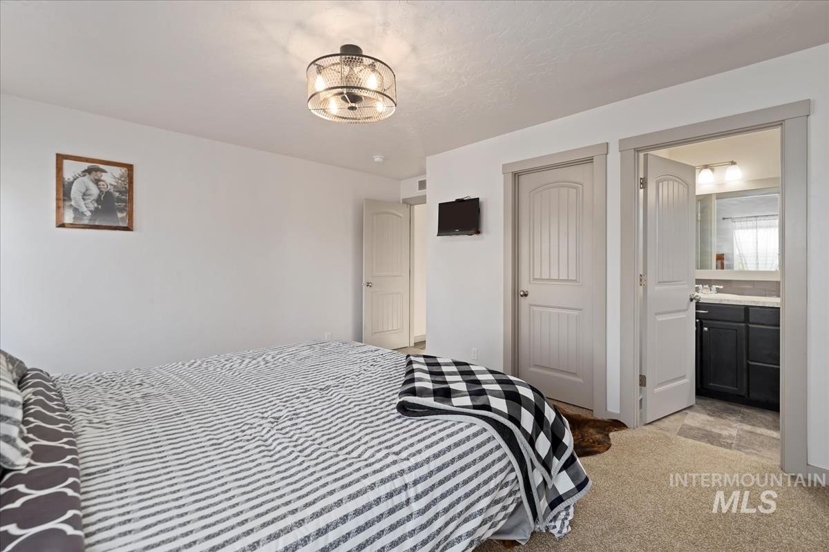 17571 Goodson Road Caldwell, ID 83607 - Photo 12 of 36 Bedroom featuring light colored carpet, a closet, and ensuite bathroom