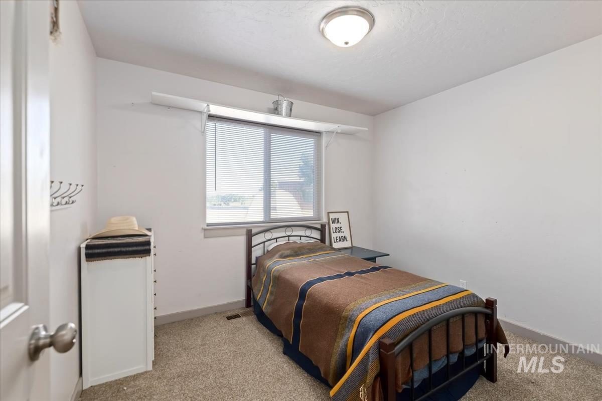 17571 Goodson Road Caldwell, ID 83607 - Photo 17 of 36 Bedroom featuring light carpet and baseboards
