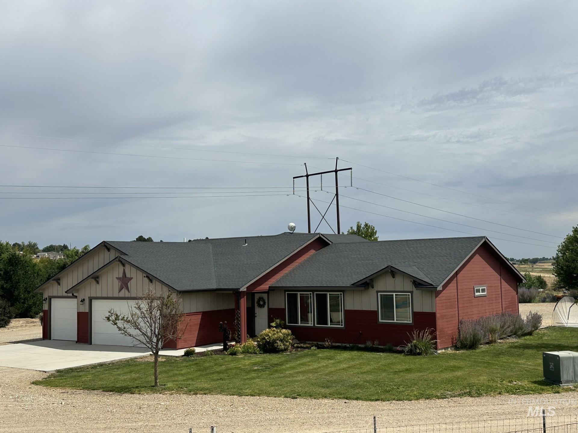 17571 Goodson Road Caldwell, ID 83607 - Photo 2 of 36 Ranch-style house with a garage, concrete driveway, board and batten siding, a front yard, and roof with shingles