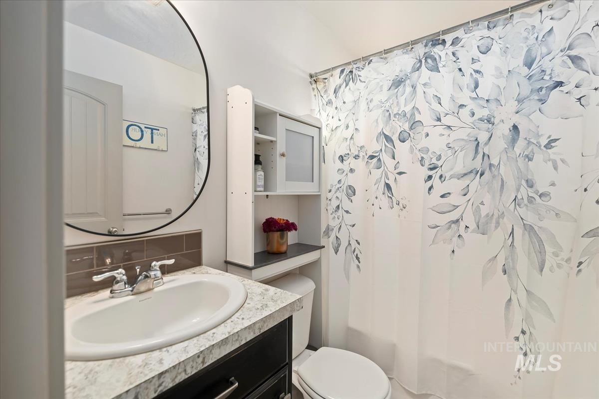 17571 Goodson Road Caldwell, ID 83607 - Photo 18 of 36 Bathroom with vanity and decorative backsplash
