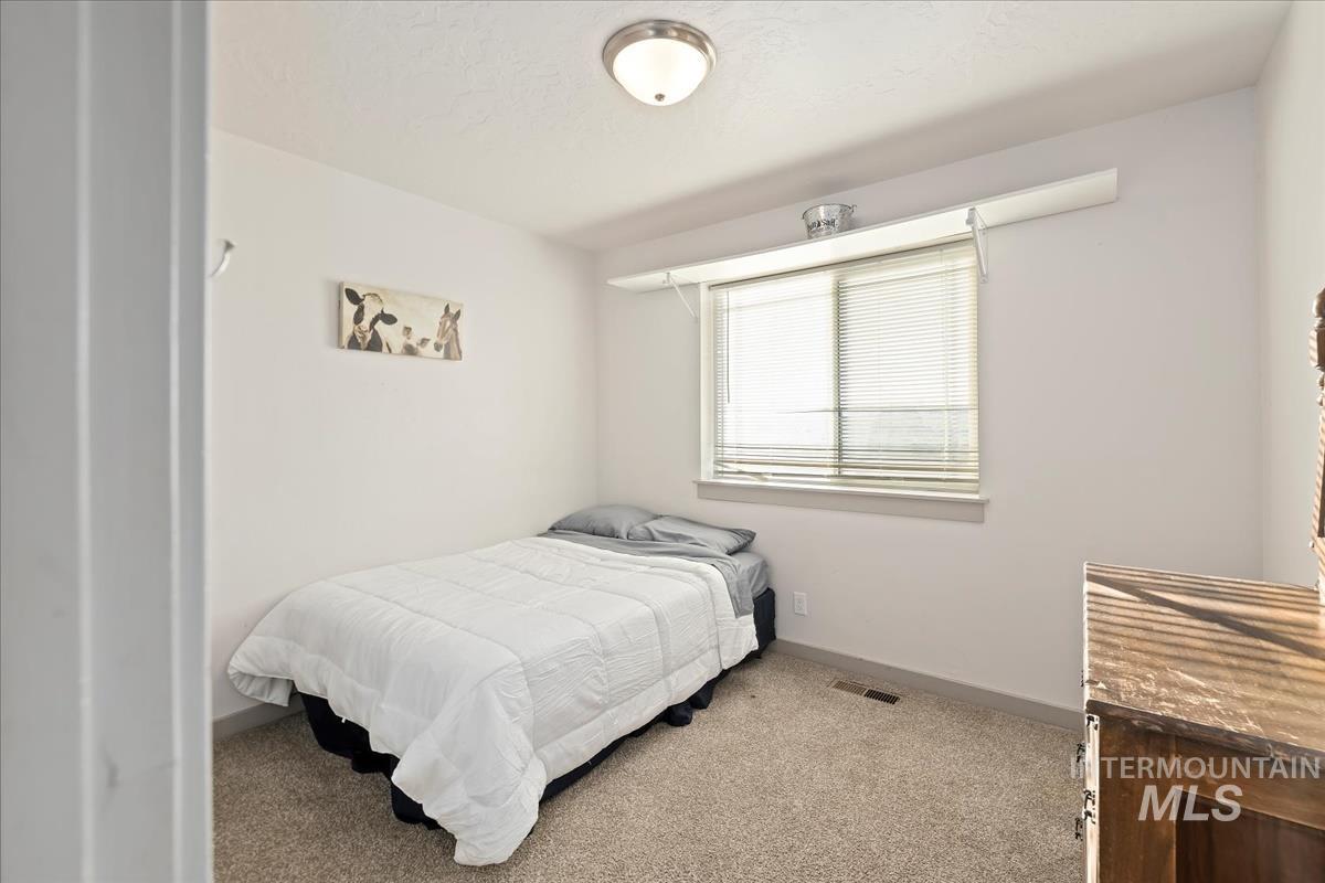 17571 Goodson Road Caldwell, ID 83607 - Photo 19 of 36 Bedroom with baseboards and light carpet