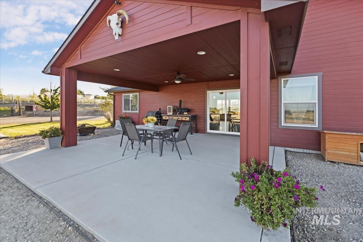 17571 Goodson Road Caldwell, ID 83607 - Photo 28 of 36 View of patio featuring a ceiling fan, outdoor dining space, and an outdoor fire pit