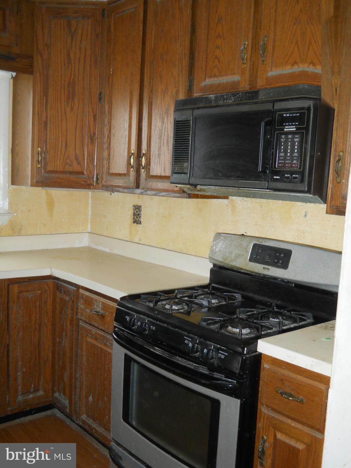 7506 Rockridge Road Baltimore, MD 21208 - Photo 6 of 12 a kitchen with granite countertop a stove and a microwave