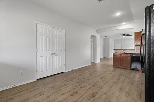 a kitchen with stainless steel appliances granite countertop a stove top oven a sink dishwasher and a refrigerator with wooden floor