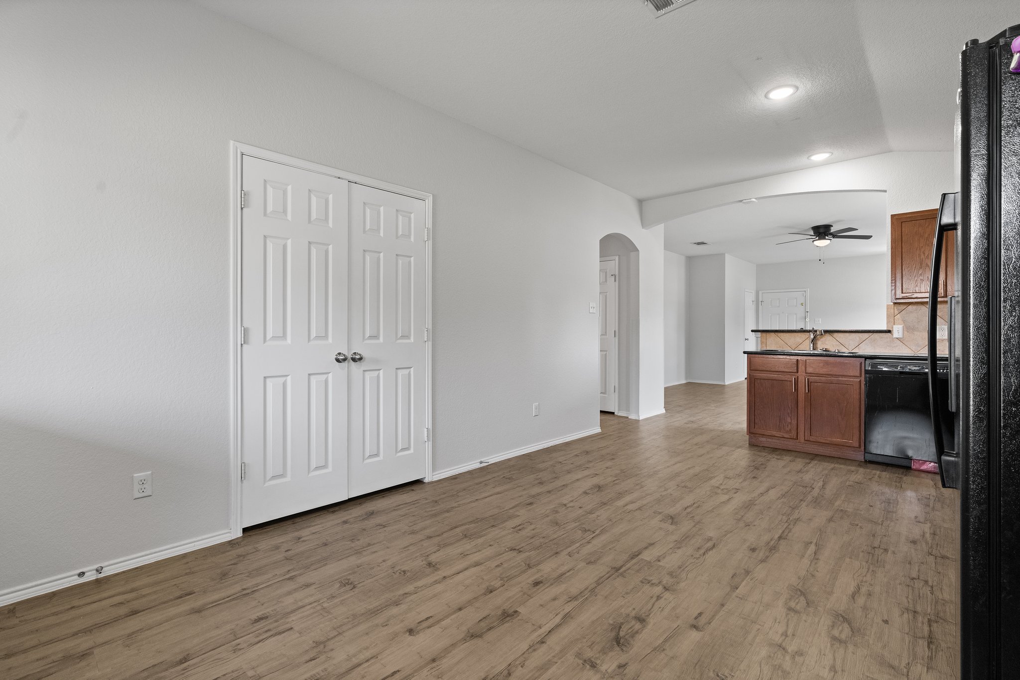5800 Maciver Drive Austin, TX 78754 - Photo 11 of 27 Unfurnished living room featuring arched walkways, light wood-style flooring, recessed lighting, and ceiling fan