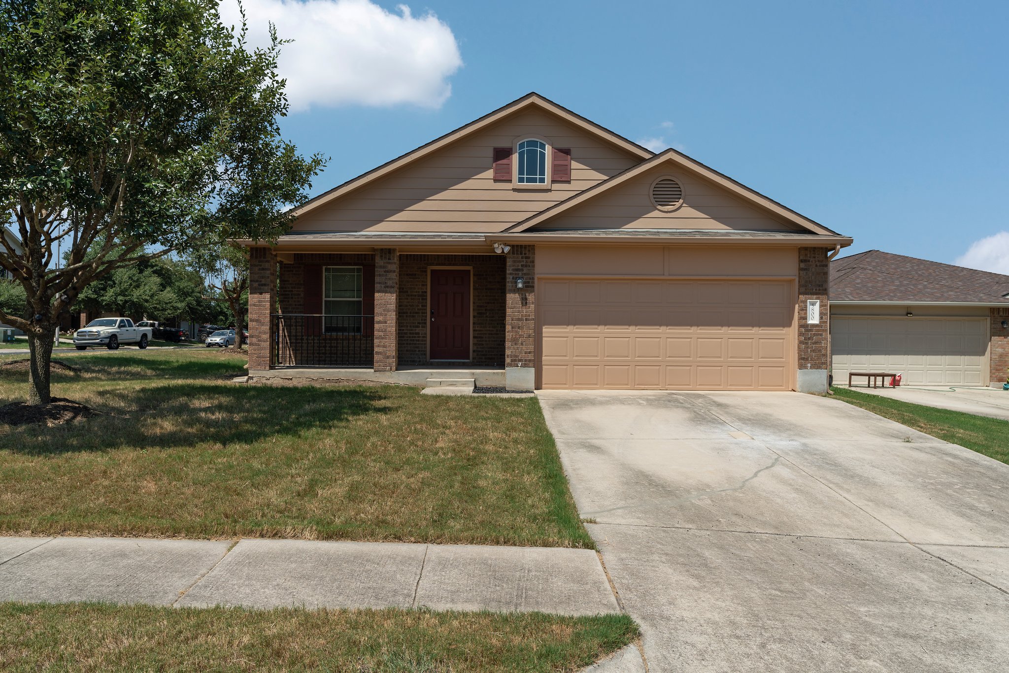 5800 Maciver Drive Austin, TX 78754 - Photo 2 of 27 View of front of home featuring a porch, brick siding, a front yard, and an attached garage