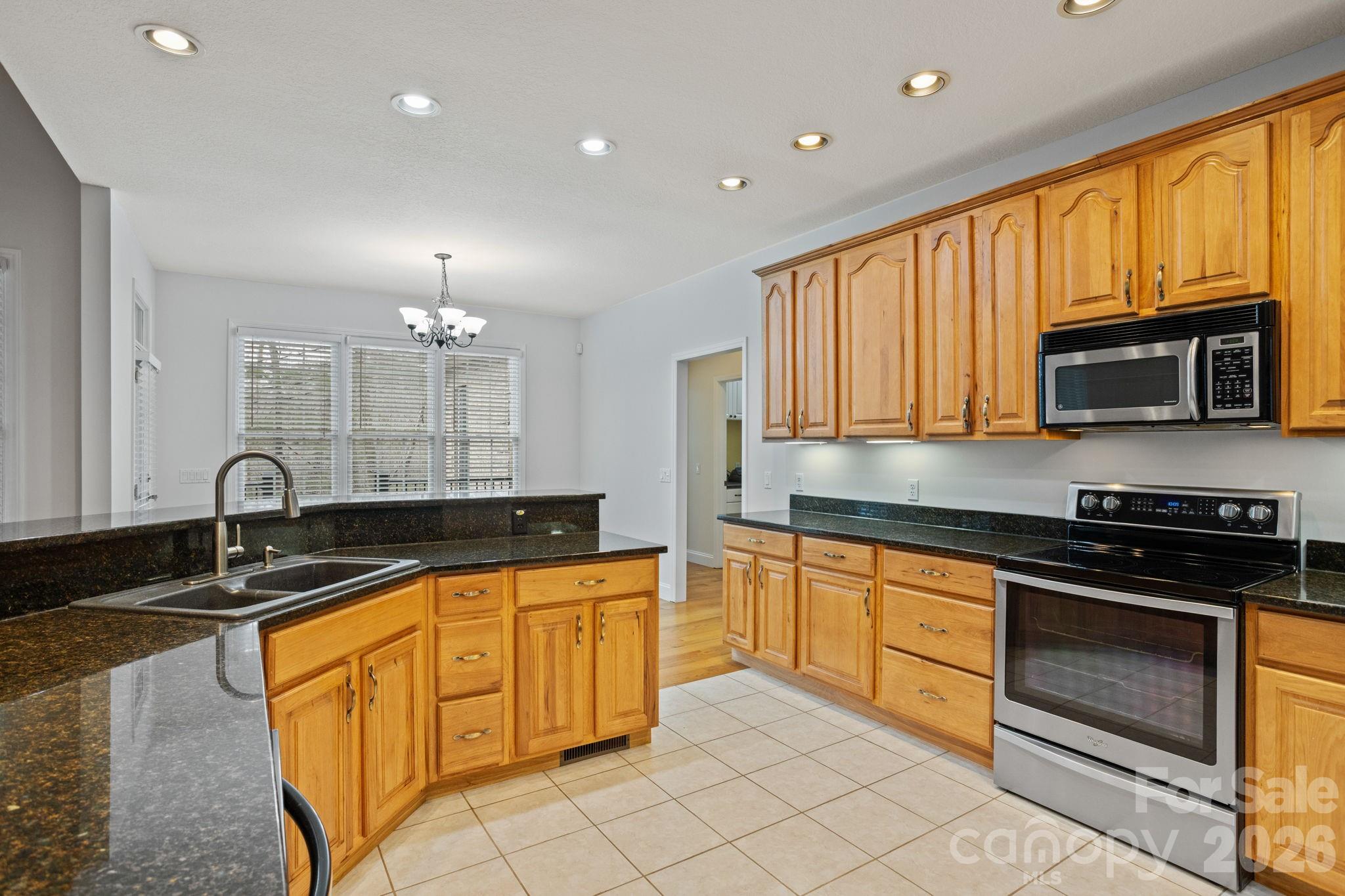 199 Judson Ridge Road Arden, NC 28704 - Photo 20 of 48 a kitchen with granite countertop a sink stove and cabinets