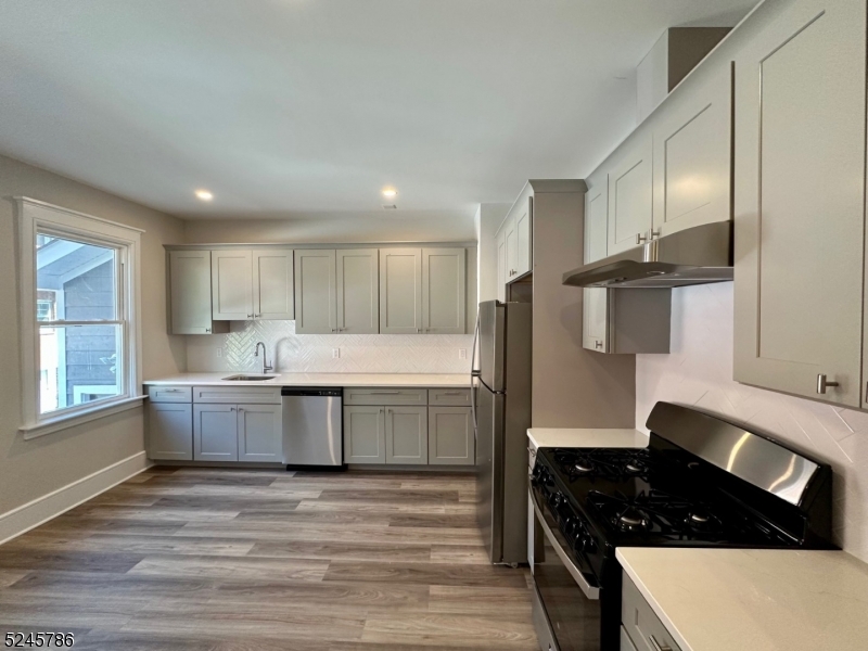 41 Harrison Avenue, Unit 1 Montclair, NJ 07042 - Photo 3 of 16 a kitchen with granite countertop a stove a sink and a refrigerator