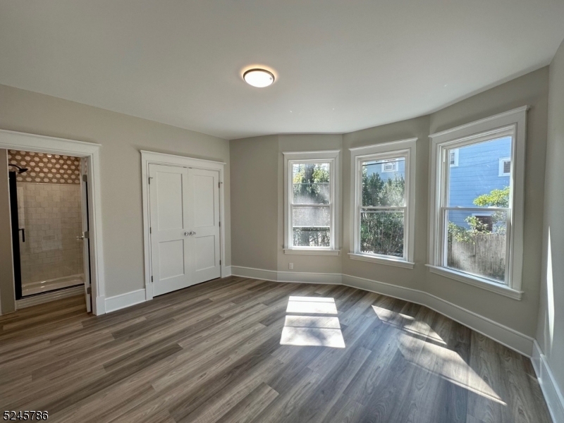 41 Harrison Avenue, Unit 1 Montclair, NJ 07042 - Photo 9 of 16 an empty room with wooden floor and windows
