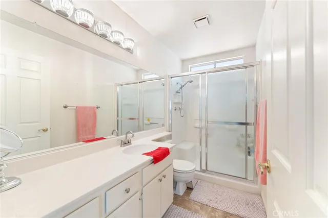 a bathroom with a sink vanity mirror and shower