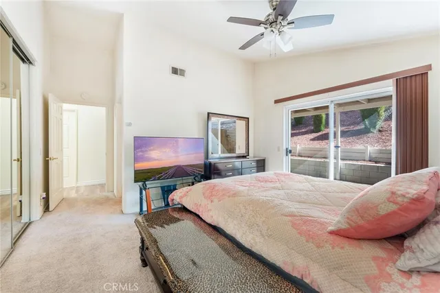 a bedroom with a bed and a mirror on the dresser