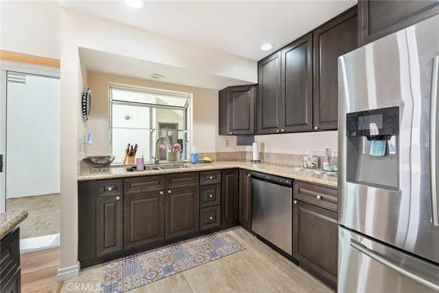 a kitchen with a refrigerator sink and cabinets