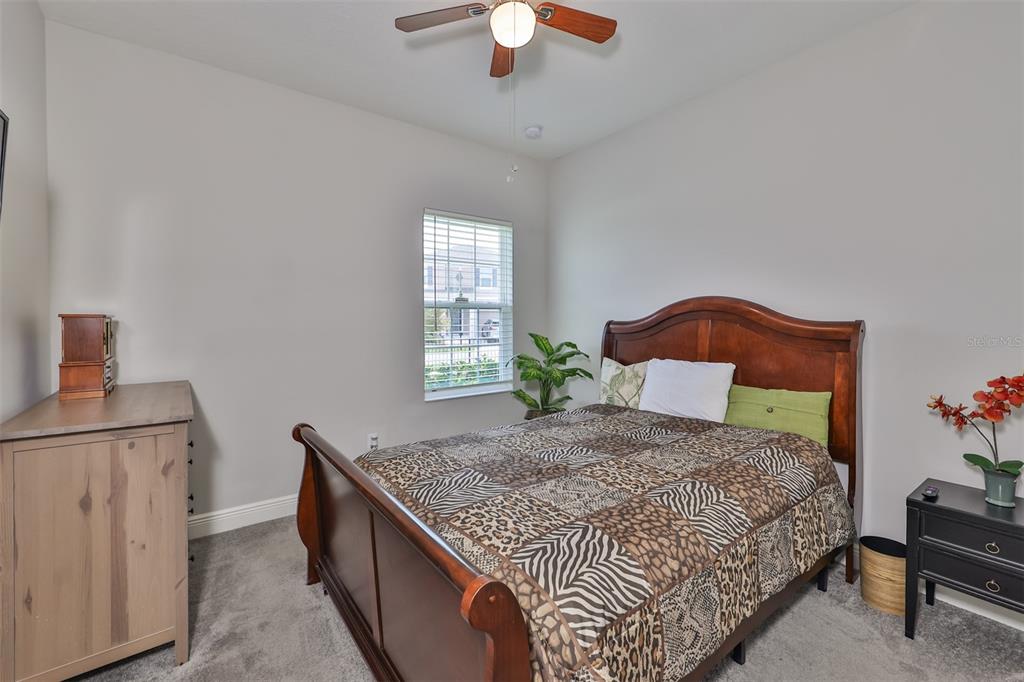 7411 Windport Lane Apollo Beach, FL 33572 - Photo 32 of 71 a bedroom with a bed and a chandelier