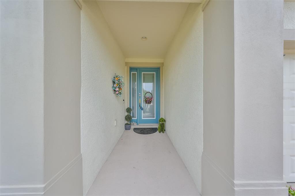 7411 Windport Lane Apollo Beach, FL 33572 - Photo 5 of 71 a view of a hallway with wooden floor and a bathroom