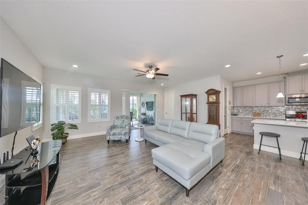 7411 Windport Lane Apollo Beach, FL 33572 - Photo 10 of 71 a living room with furniture or wooden floor and a flat screen tv