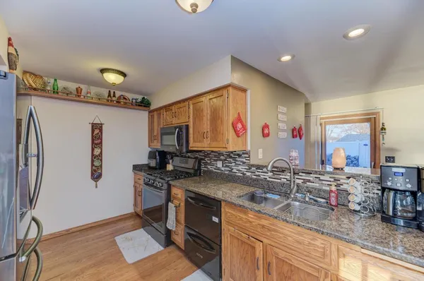 a kitchen with stainless steel appliances granite countertop a sink stove and refrigerator