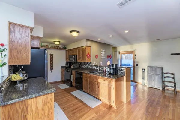 a kitchen with stainless steel appliances granite countertop a sink stove and refrigerator
