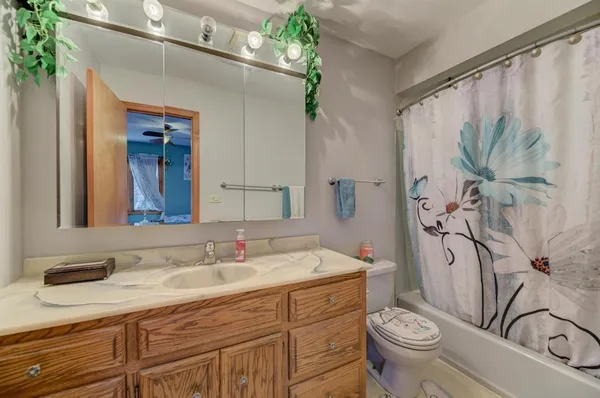 a bathroom with a granite countertop sink toilet and shower
