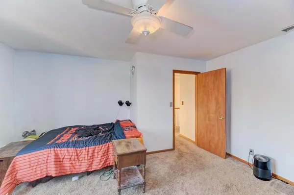 a bedroom with furniture and a chandelier fan