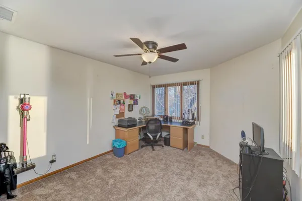 a view of a workspace with furniture and a window