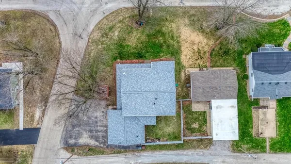 an aerial view of a house with a yard and large tree