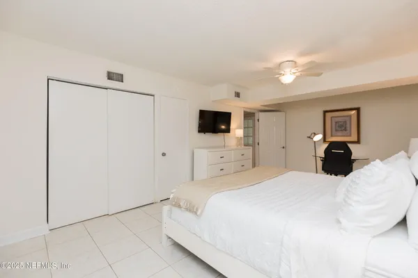 a large bedroom with a bed and a flat screen tv