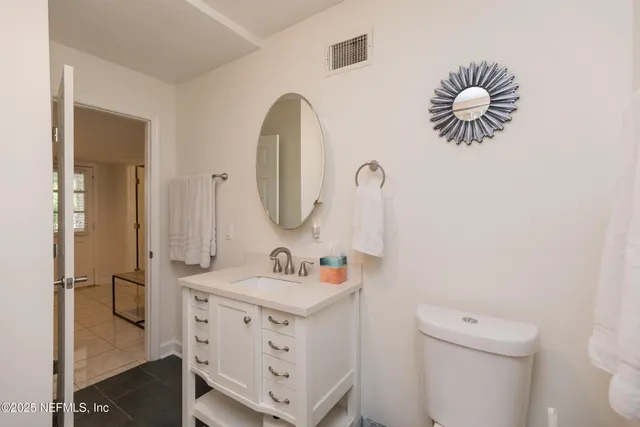 a bathroom with a sink a toilet and a mirror