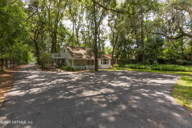 a view of a house with a yard and tree s