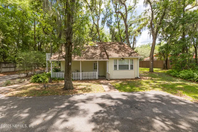 a view of a house with backyard and a tree