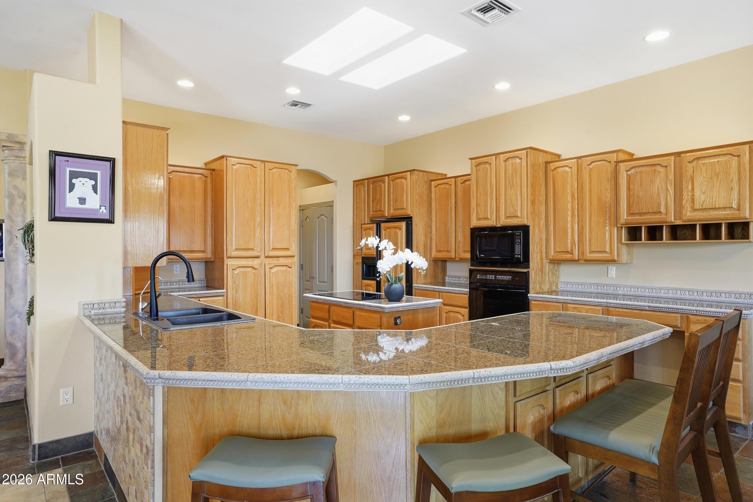 6334 East Albany Street Mesa, AZ 85205 - Photo 17 of 72 a room with stainless steel appliances kitchen island granite countertop a sink and cabinets