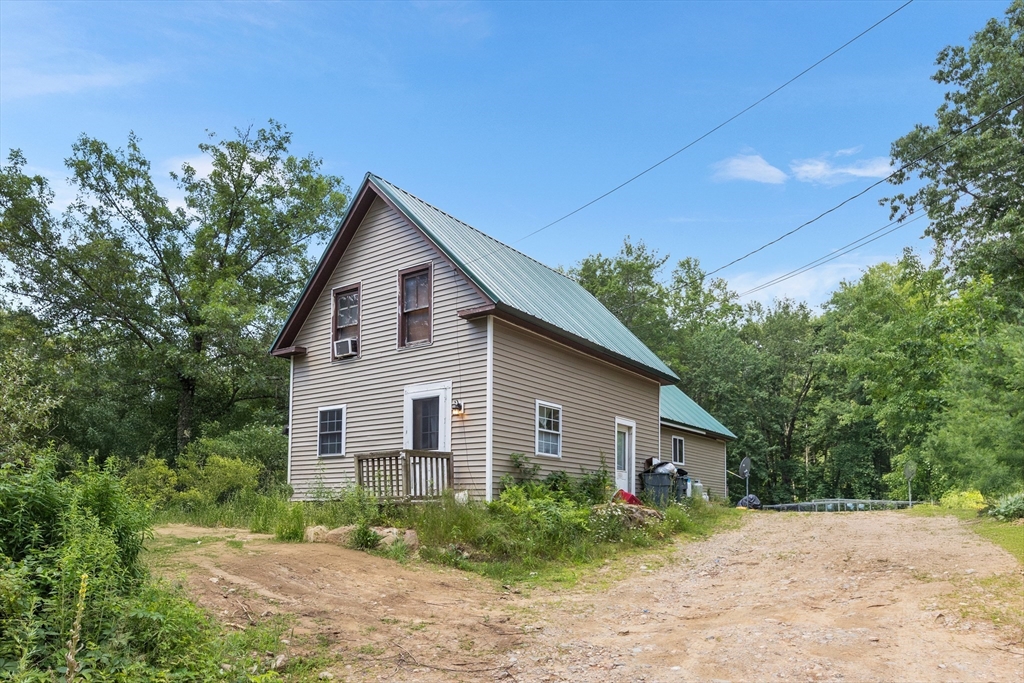 87 W Road Canterbury, NH 03224 - Photo 1 of 21 a front view of a house with a garden