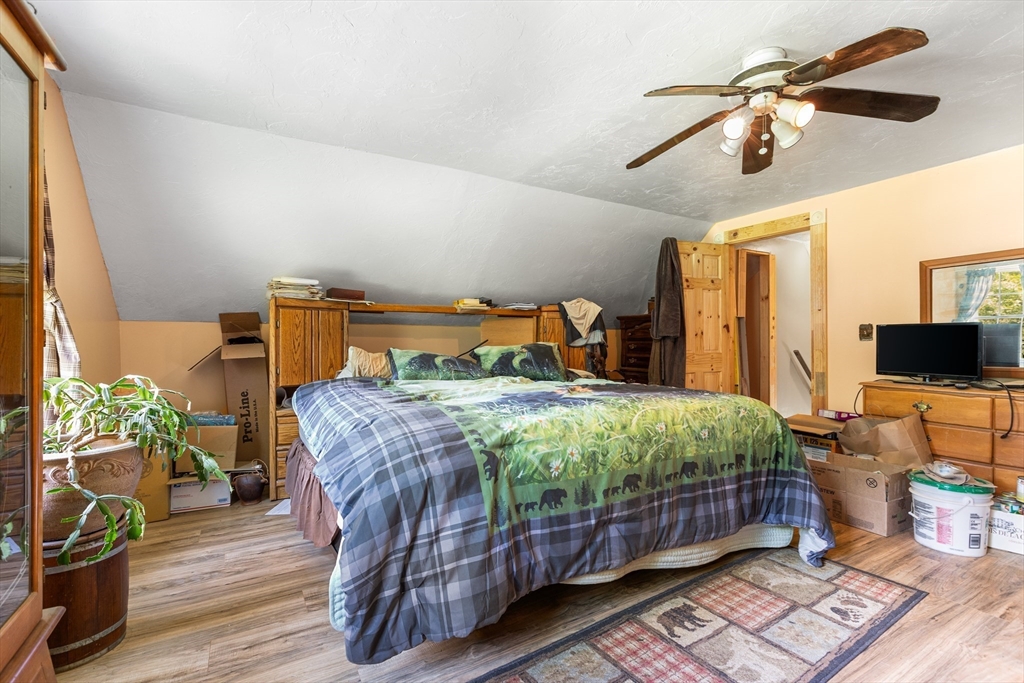 87 W Road Canterbury, NH 03224 - Photo 11 of 21 a bedroom with a bed a flat screen tv and a chandelier