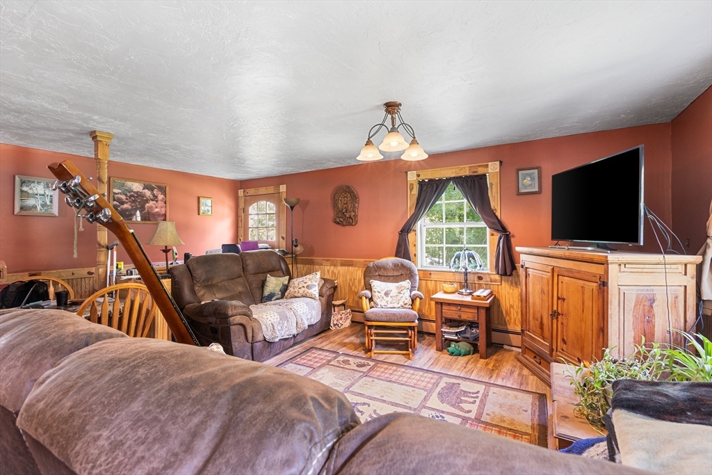 87 W Road Canterbury, NH 03224 - Photo 5 of 21 a living room with furniture a flat screen tv and a window