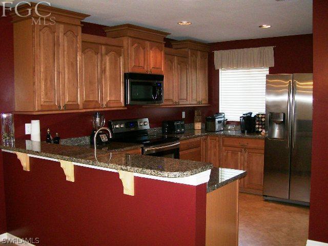 17568 Homewood Road Fort Myers, FL 33967 - Photo 8 of 18 a kitchen with stainless steel appliances granite countertop a sink a stove and a refrigerator