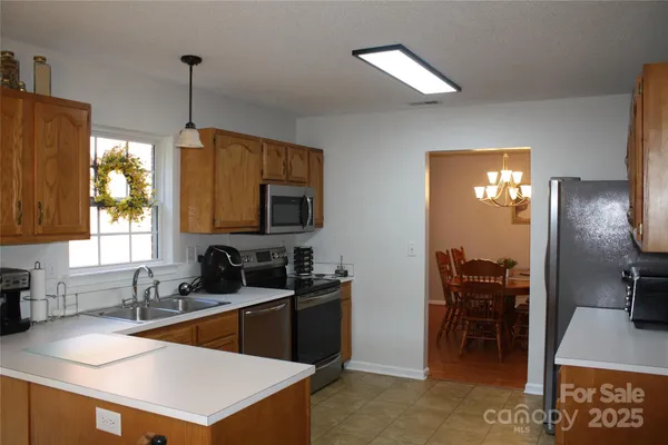 a kitchen with stainless steel appliances granite countertop a sink a stove and a refrigerator