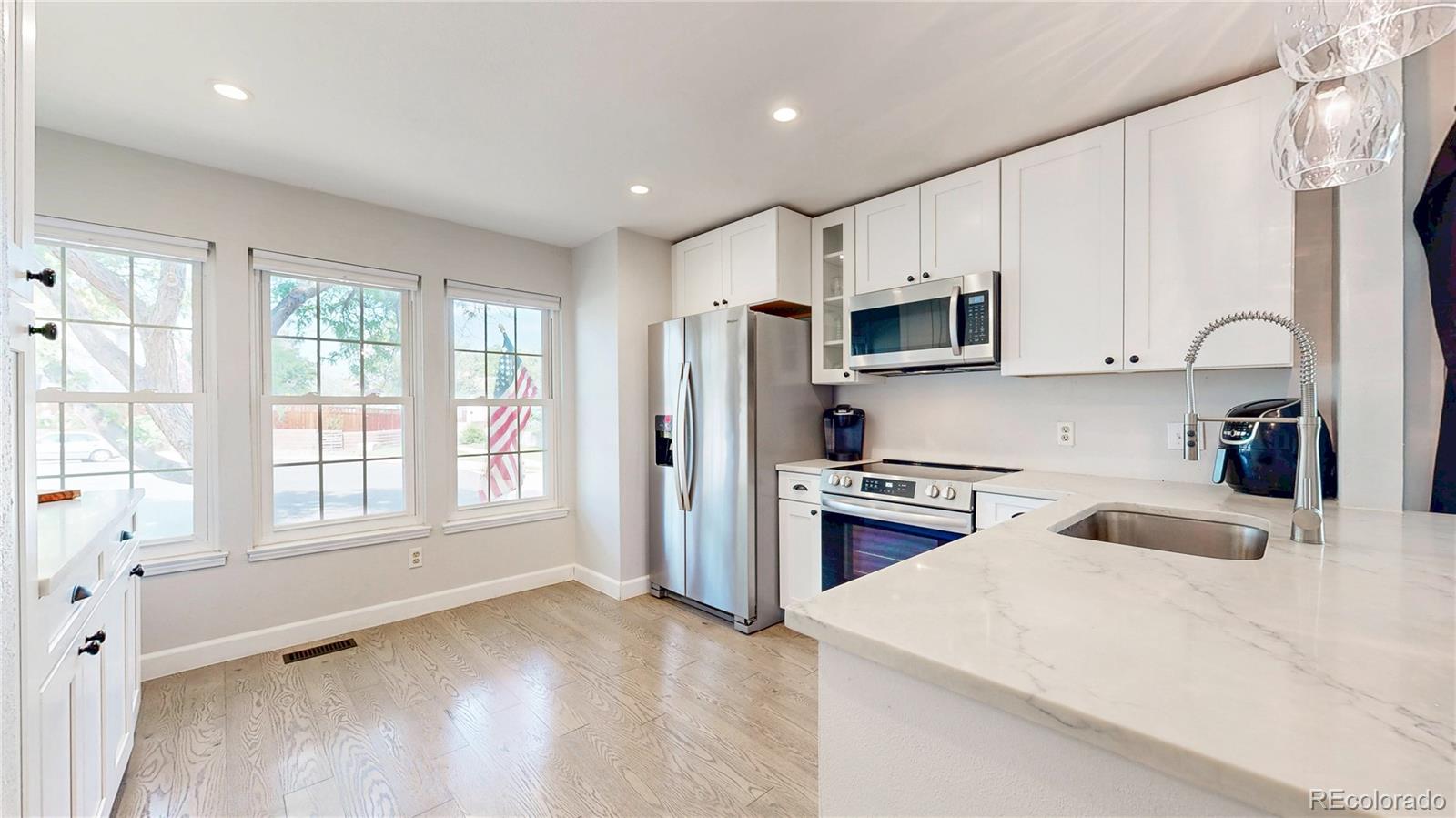 13322 Ash Circle Thornton, CO 80241 - Photo 3 of 48 a kitchen with granite countertop a refrigerator stove top oven and sink
