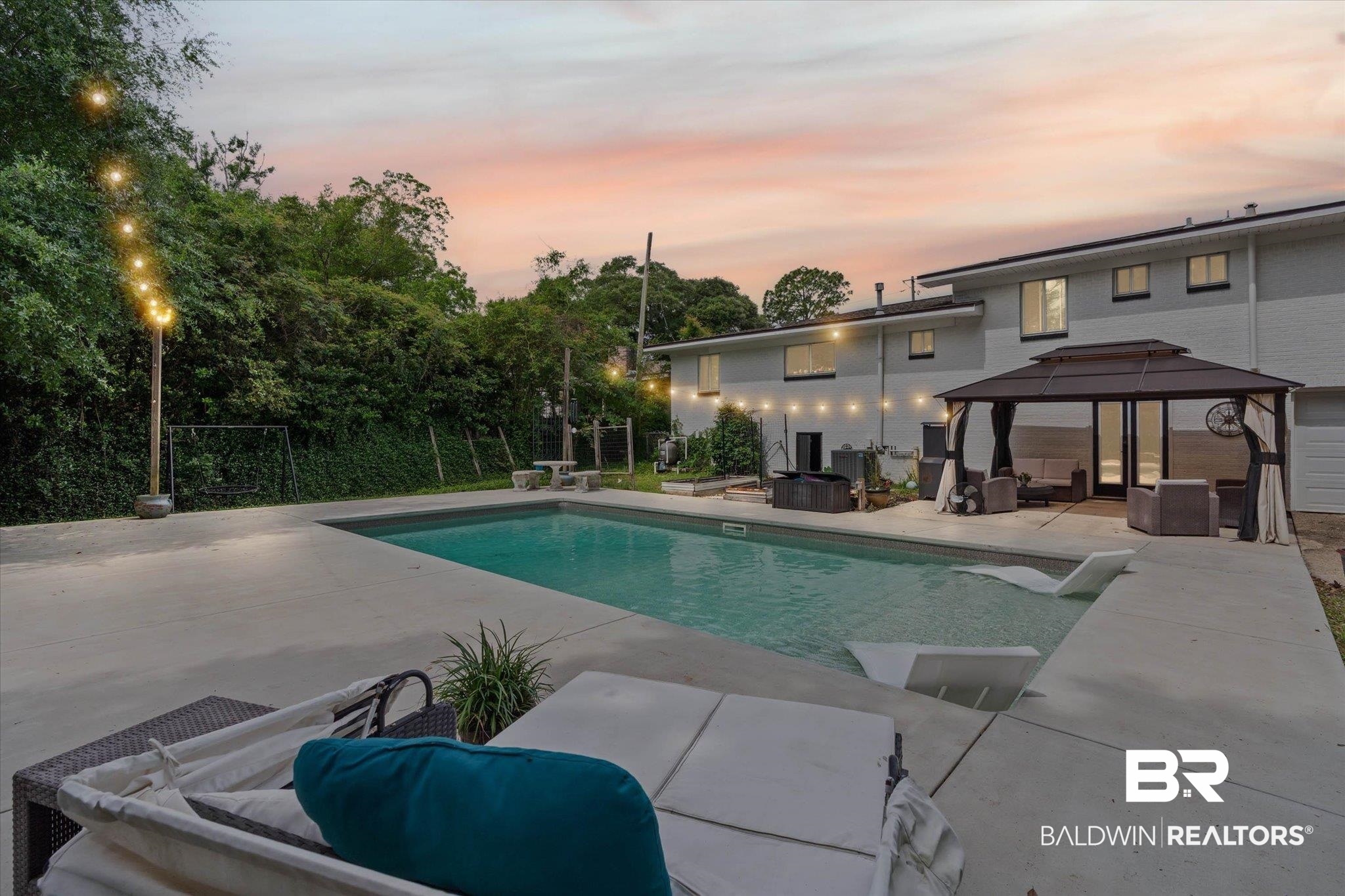 4213 Shan Drive East Mobile, AL 36693 - Photo 2 of 35 Concrete patio with a rectangular swimming pool, an adjacent gazebo structure, and string lighting