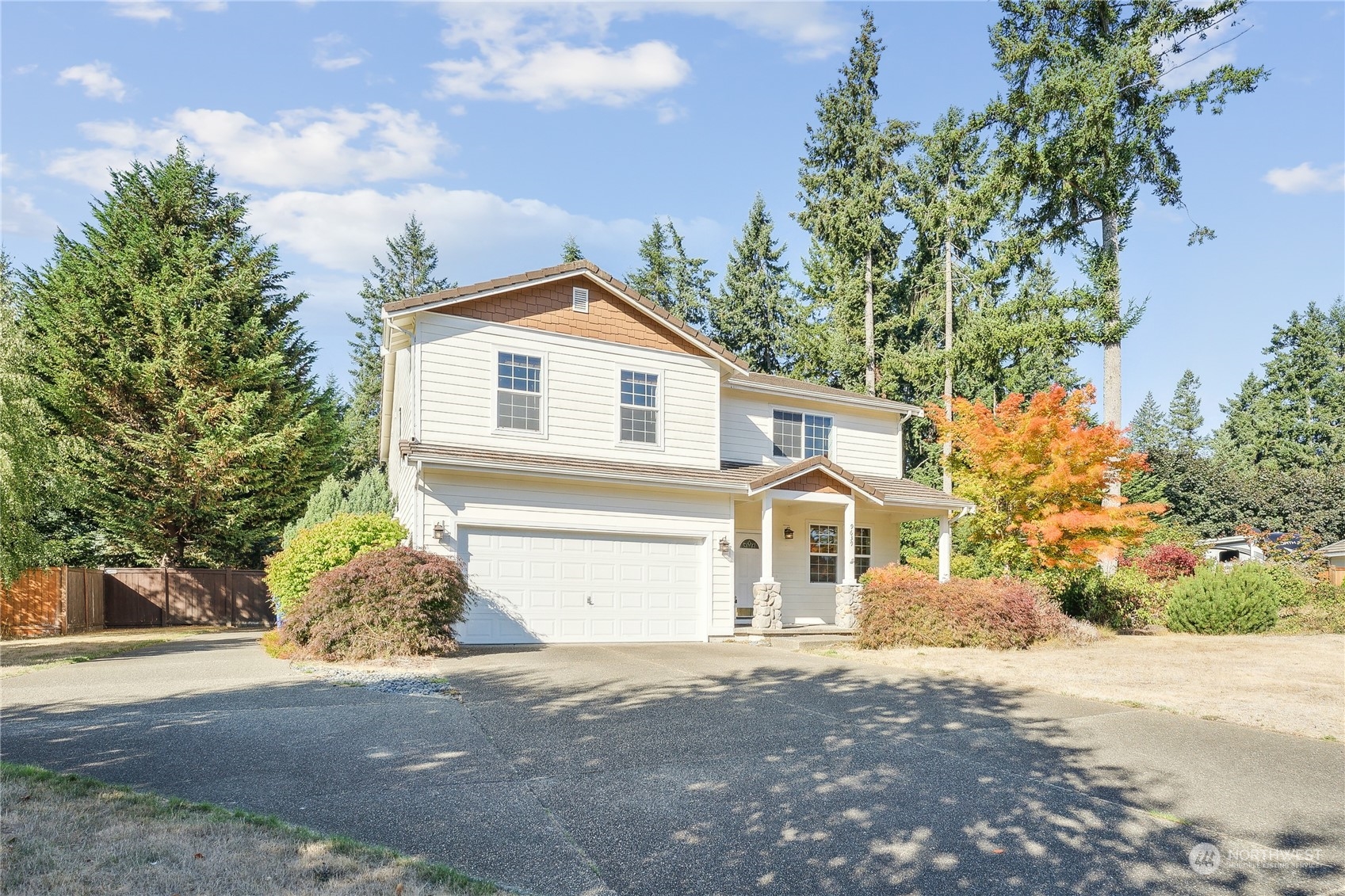 a view of a white house with a yard and a tree