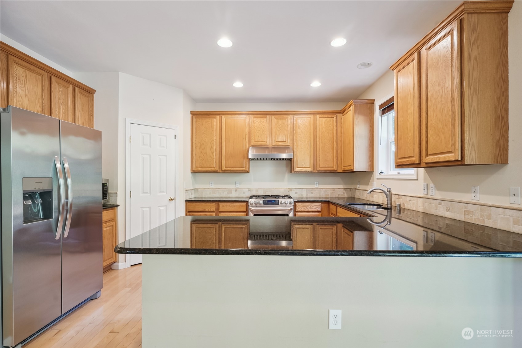 9639 39th Loop Northeast Olympia, WA 98516 - Photo 14 of 38 a kitchen with granite countertop a sink a counter top space appliances and cabinets