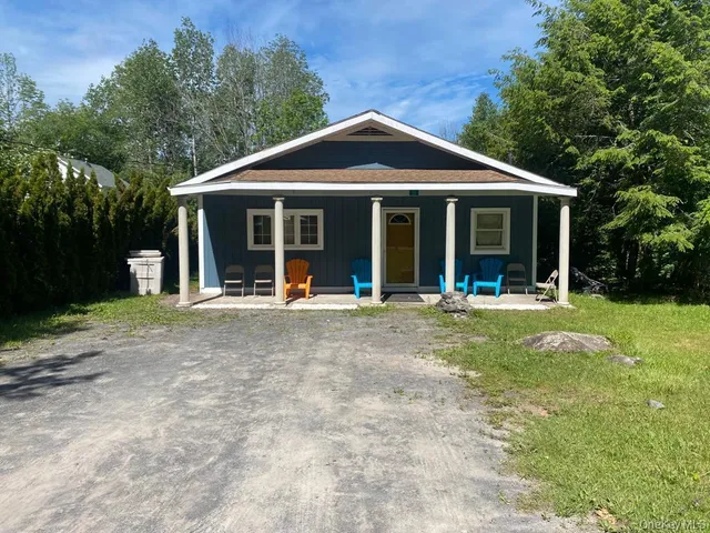 a view of a house with a yard and potted plants