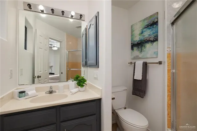 a bathroom with a sink vanity mirror and toilet