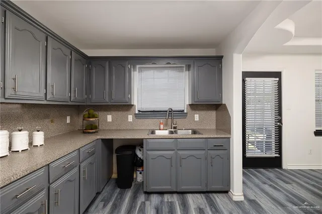 a kitchen with a sink cabinets and wooden floor