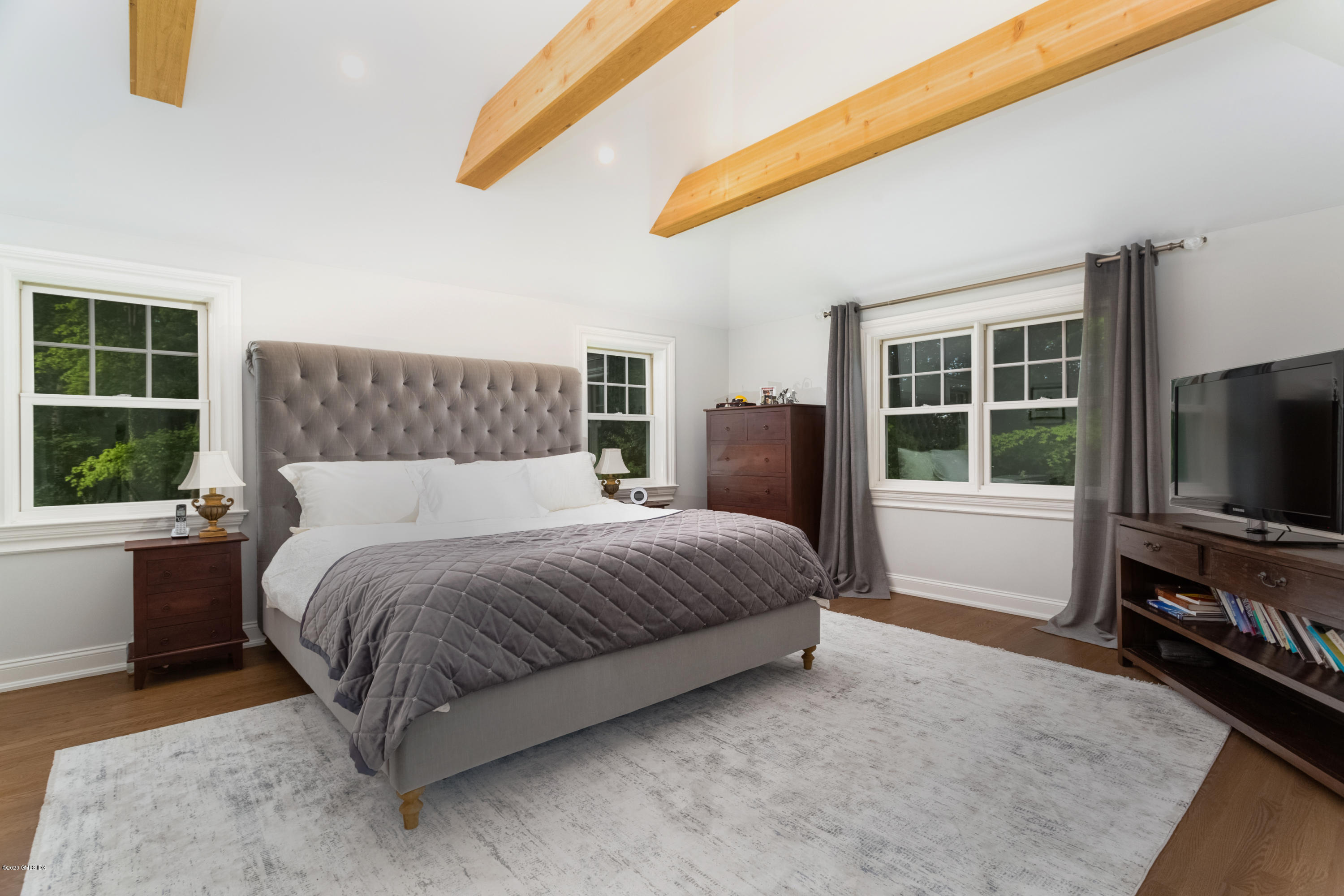 36 Evergreen Road Greenwich, CT 06830 - Photo 22 of 40 a spacious bedroom with a bed and a flat tv screen on dresser
