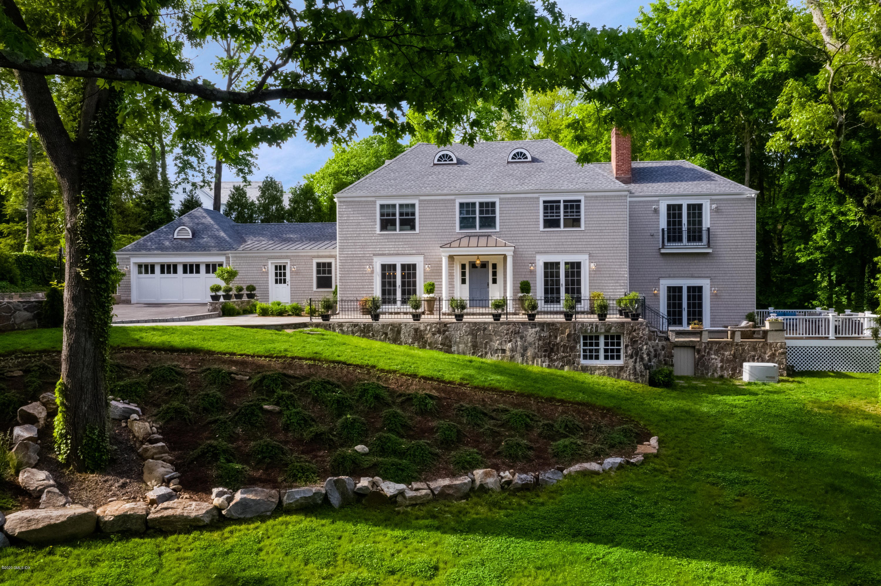36 Evergreen Road Greenwich, CT 06830 - Photo 3 of 40 a front view of a house with garden and trees