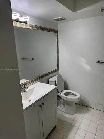 a bathroom with a sink mirror vanity and toilet