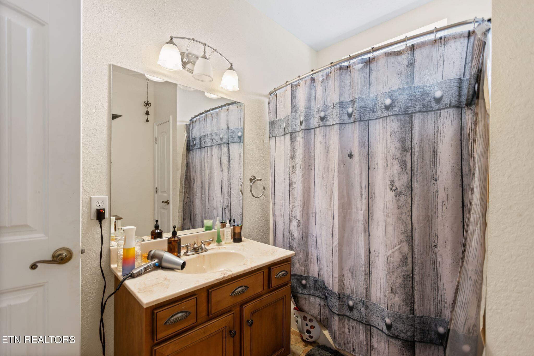 741 Clinch Valley Road Powder Springs, TN 37848 - Photo 27 of 50 a bathroom with a sink a mirror and shower curtain