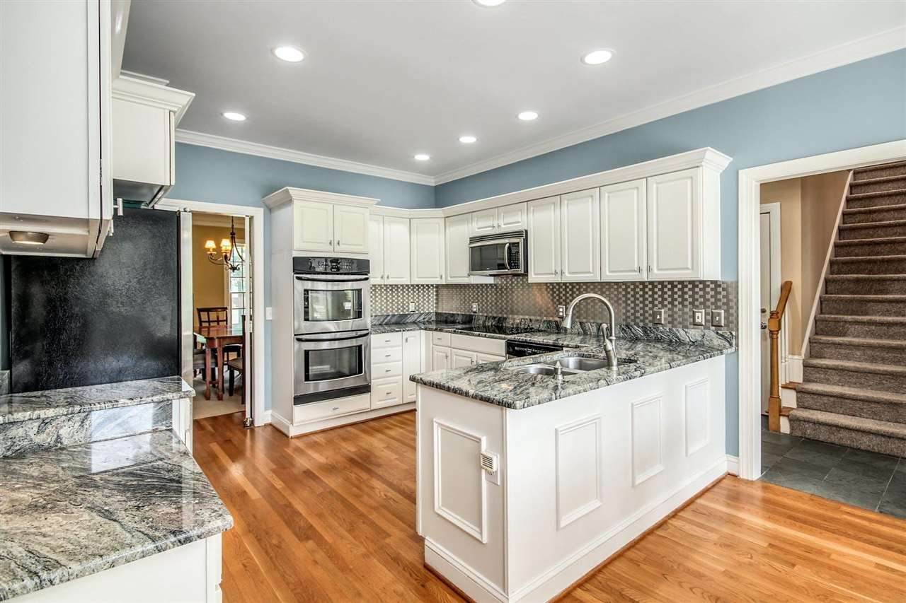 4812 Salem Ridge Road Holly Springs, NC 27540 - Photo 15 of 30 Rear Staircase! Room near stairs being used as 2nd fridge area. W/D hookups behind 2nd Fridge for convesrion to 1st floor laundry. Kitchen View