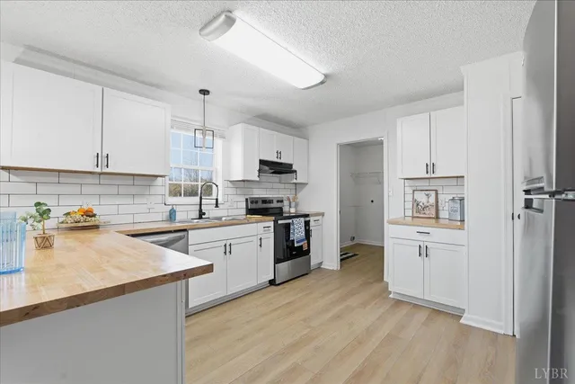 a kitchen with a refrigerator cabinets and wooden floor