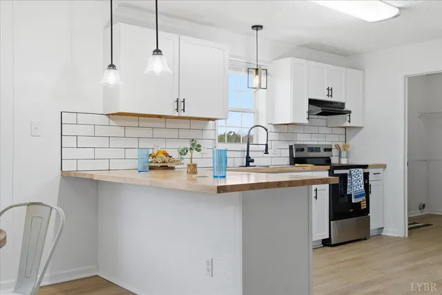 a kitchen with stainless steel appliances granite countertop a sink a stove and a refrigerator