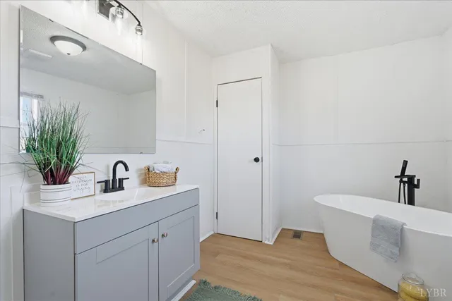 a bathroom with a bathtub sink and mirror